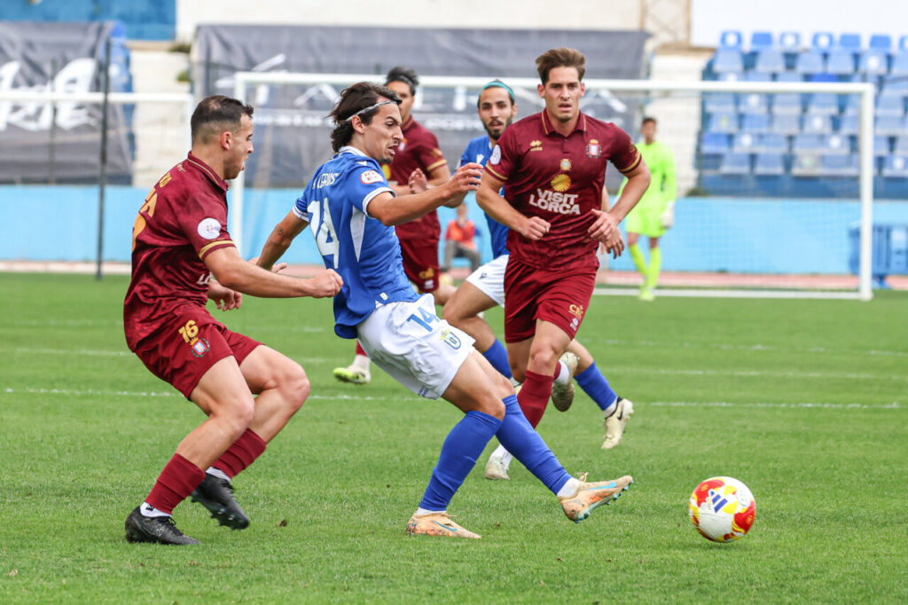 Jugadores de fútbol en un partido entre U.D. Melilla y Lorca Deportiva
