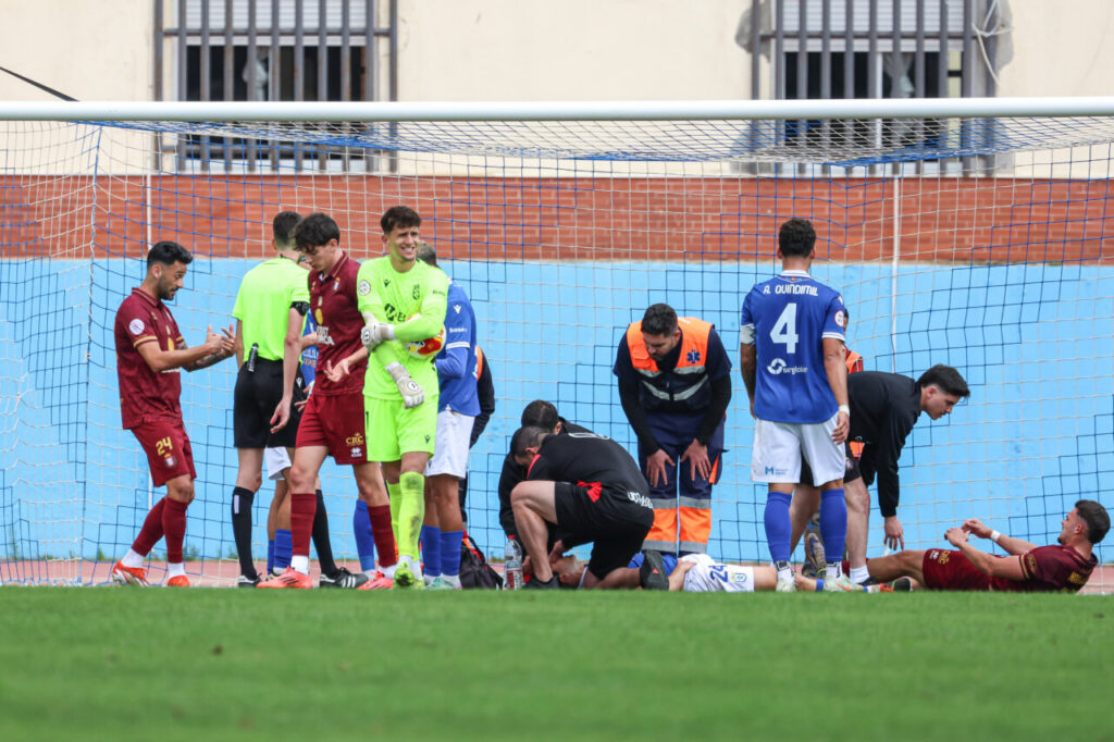 Jugadores de fútbol en el campo tras un incidente durante el partido.
