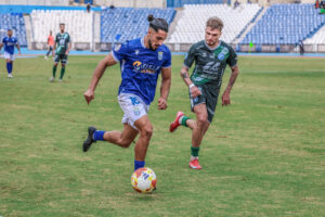 Jugador de la UD Melilla corriendo con el balón en un partido de fútbol