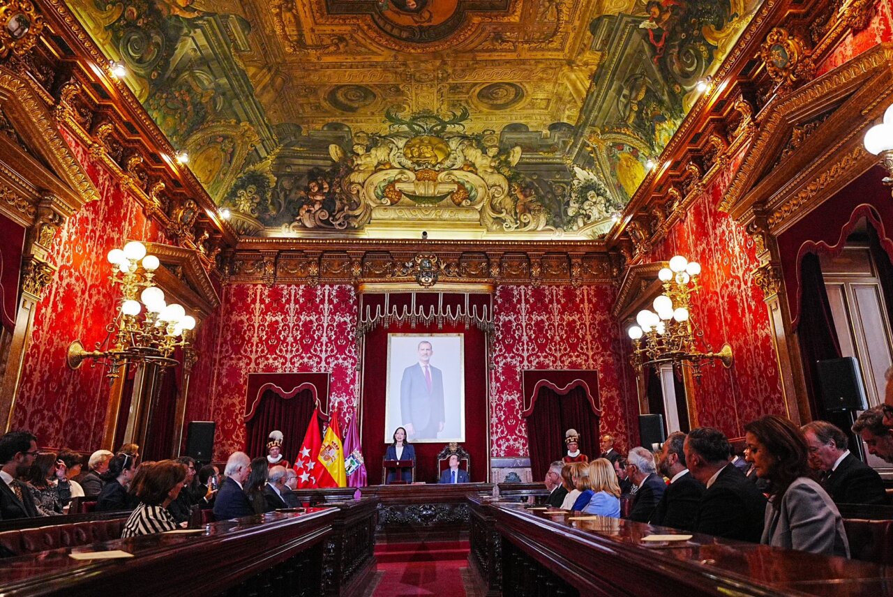 Ceremonia en un salón con decoración elaborada y retrato en el fondo