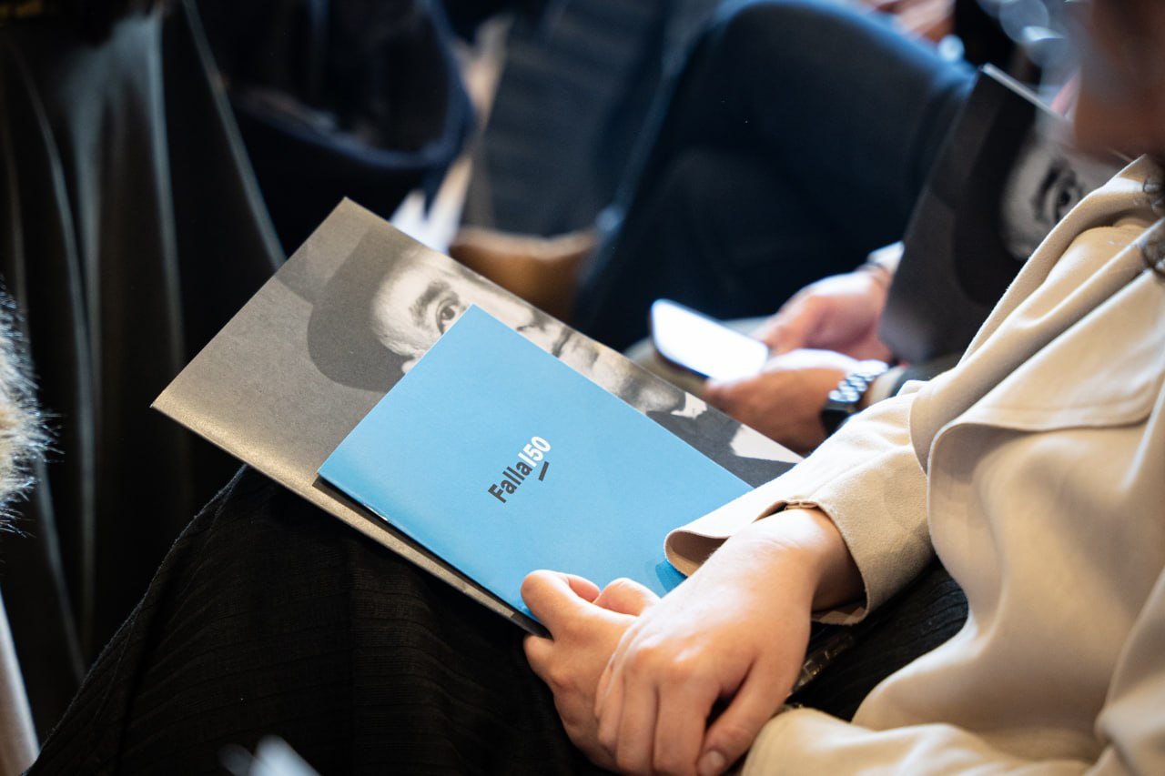 Persona sosteniendo un folleto sobre Manuel de Falla en un evento cultural.