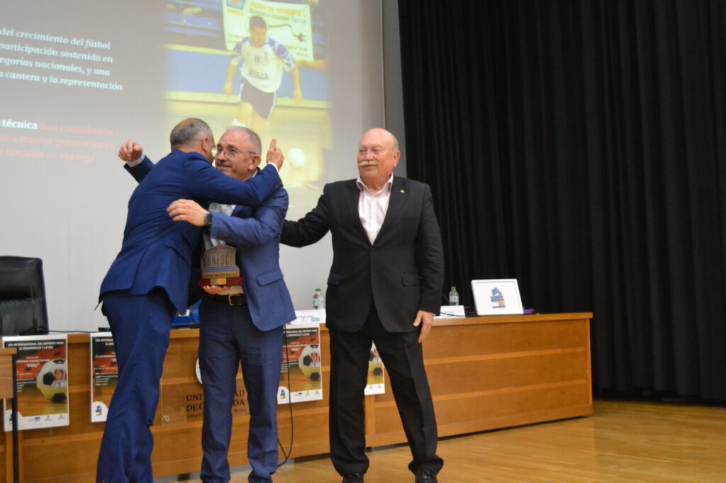Vicky recibiendo un galardón en un acto deportivo emotivo.