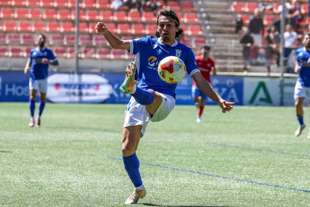 Jugador de la U.D. Melilla controla el balón durante un partido en Estepona.