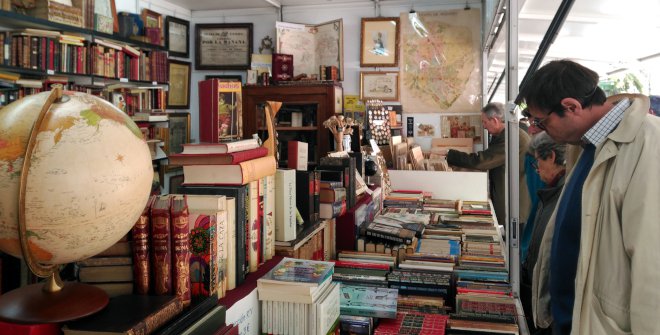 Visitantes explorando una caseta en la Feria del Libro Antiguo en Madrid