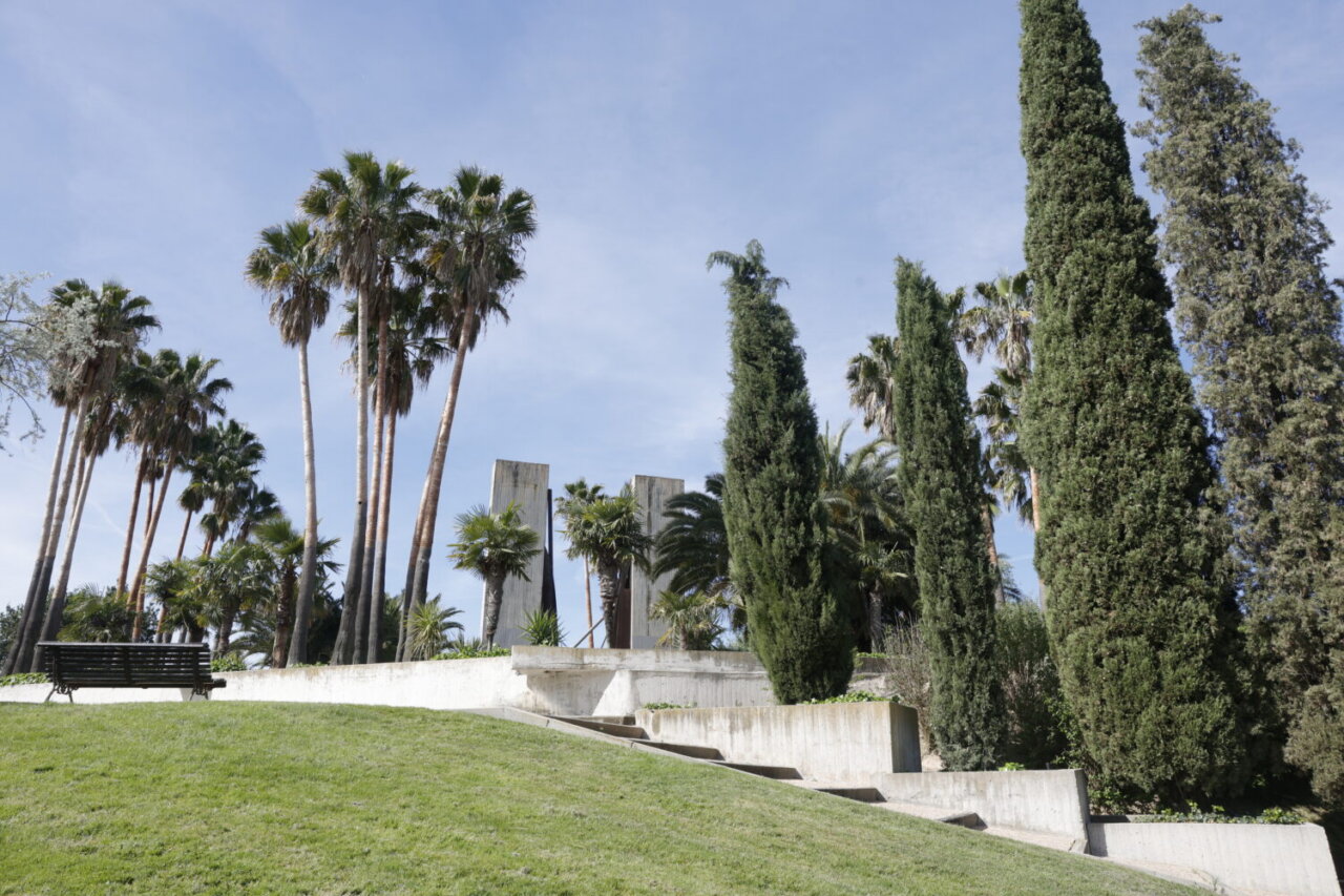 Vista del Jardín de las Tres Culturas en Barajas, Madrid, con palmeras y cipreses.