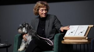 Julia Navarro presentando su libro con un perro en su regazo