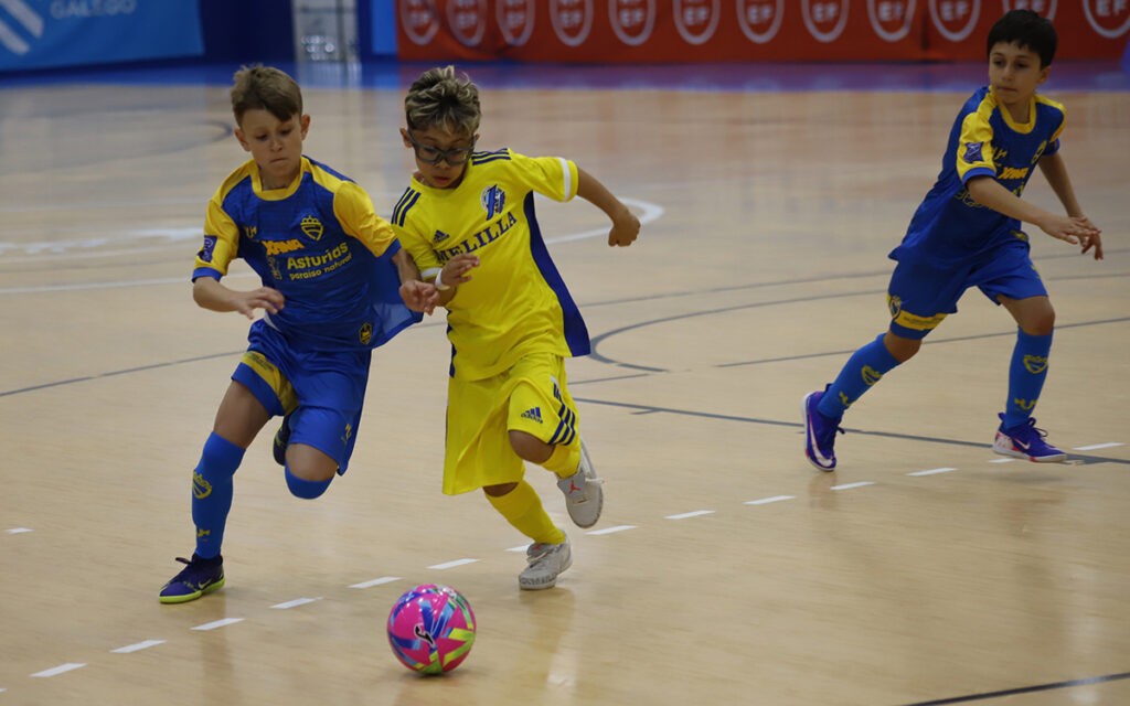 Niños jugando fútbol sala en un partido entre Melilla y Asturias