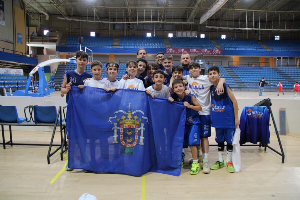 Grupo de jóvenes jugadores de baloncesto de Melilla con una bandera