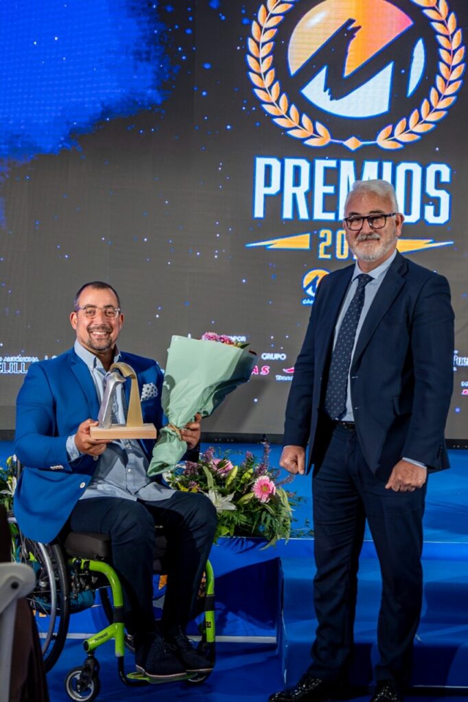Entrega de premios a deportistas en Melilla con flores y trofeo.