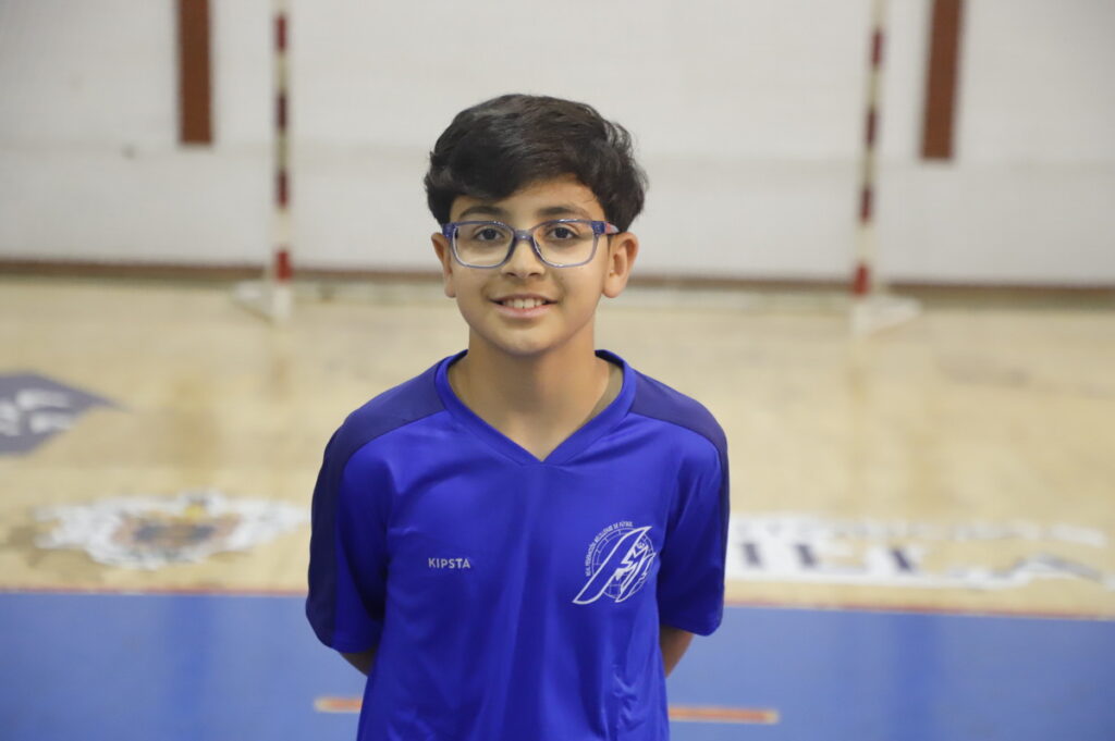 Niño sonriente con camiseta azul en un gimnasio