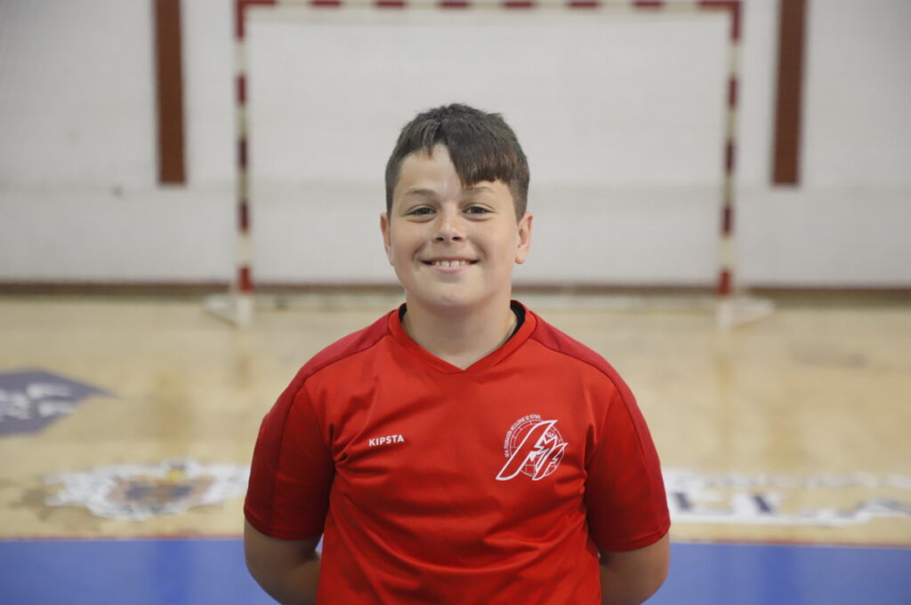 Niño sonriente con camiseta roja en un gimnasio