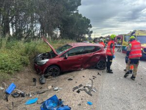 Vehículo dañado en un accidente de tráfico con rescatistas presentes