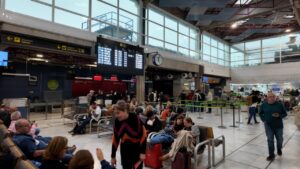Interior de un aeropuerto con pasajeros esperando en la sala de espera