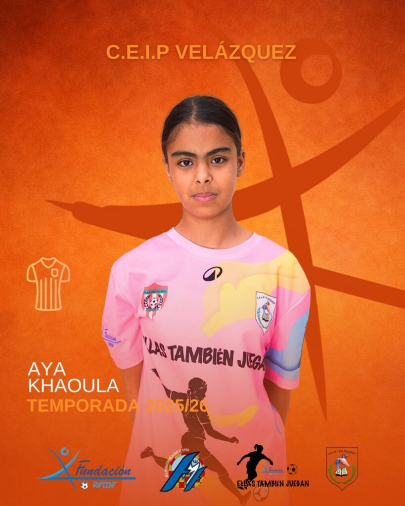 Portrait of Aya Khaoula in a pink soccer jersey, standing against an orange backdrop with team logos and season text (2025/26).