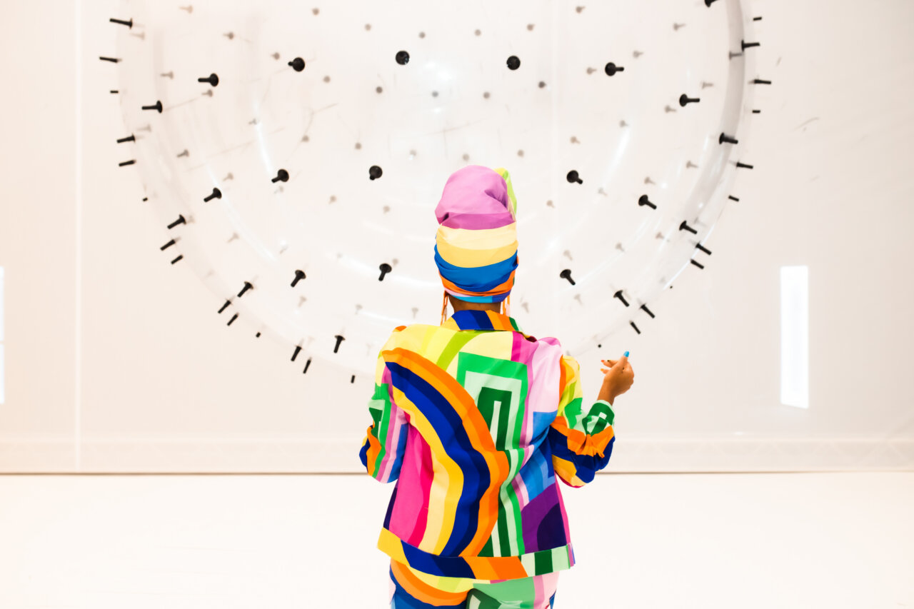 Persona con vestimenta colorida interactuando en el Balloon Museum de Madrid