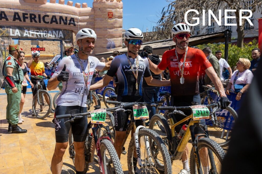 Tres ciclistas posando después de una competencia de ciclismo en Melilla.