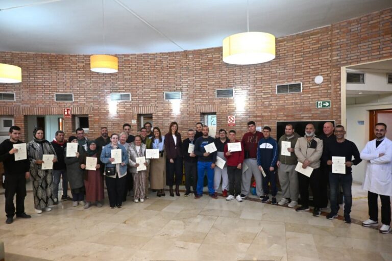 Grupo de participantes sosteniendo diplomas en el acto de clausura del programa formativo del Imserso en Melilla.