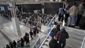 Multitud de personas en una larga cola para trámites administrativos