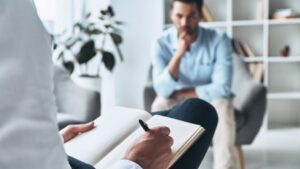 Psicólogo clínico tomando notas durante una sesión con un paciente