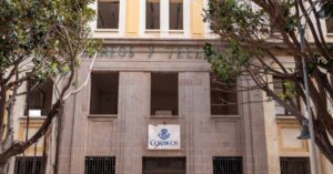 Fachada del antiguo edificio de Correos en Melilla con árboles alrededor.