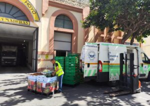 Hombre organizando cajas de frutas en el Banco de Alimentos de Melilla