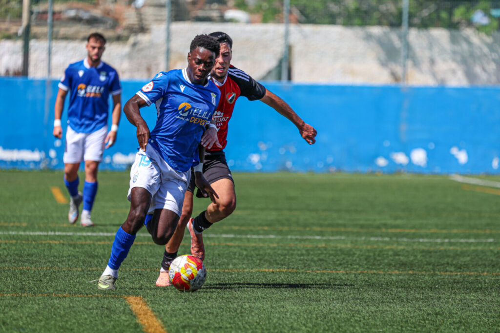 Jugadores de fútbol compitiendo en un partido entre U.D. Melilla y U.D. San Pedro.