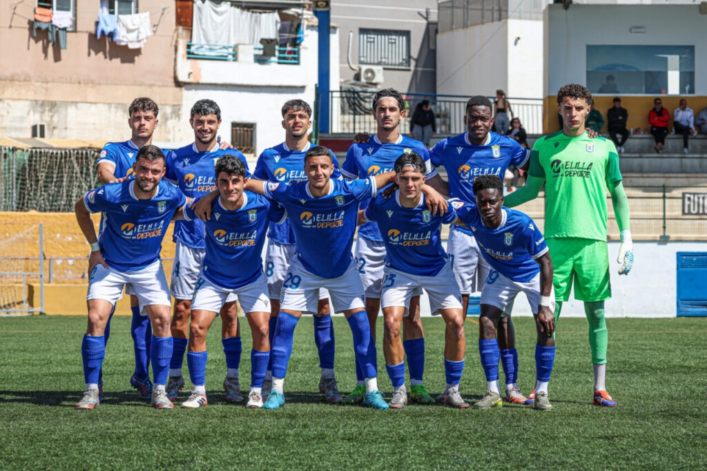 Equipo de fútbol U.D. Melilla posando en el campo