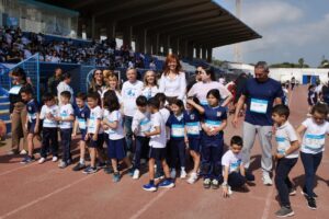 Grupo de niños y adultos en un evento deportivo escolar