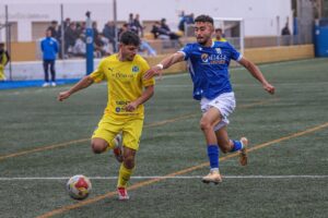 Jugadores de fútbol compiten en un partido entre U.D. Melilla y C.F. Marbellí.