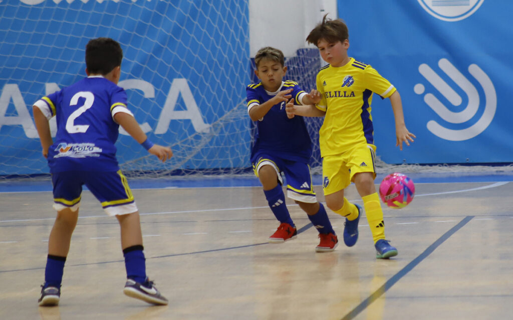 Niños jugando al fútbol en un partido infantil en la cancha