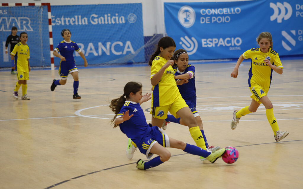 Niñas jugando al fútbol en un partido de sala