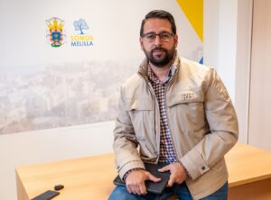 Hombre sentado con chaqueta en un entorno de oficina en Melilla