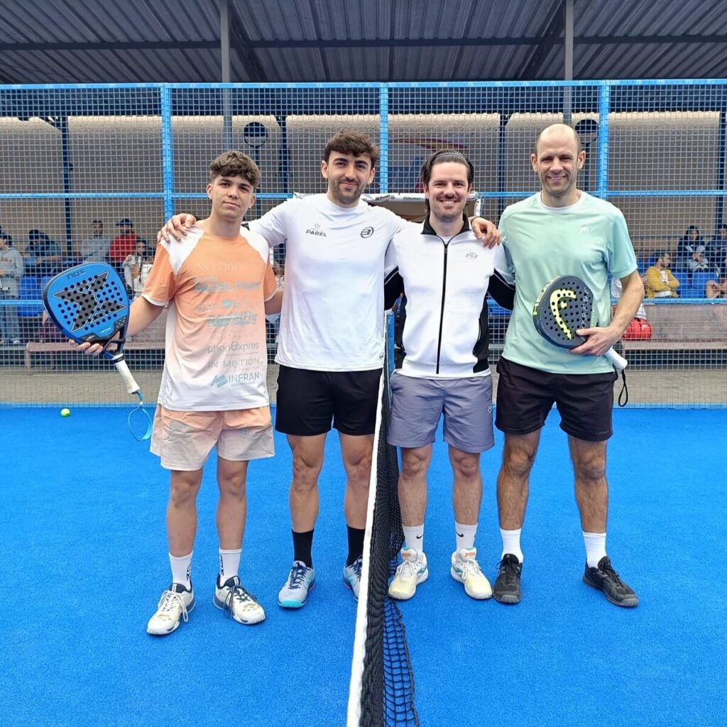 Cuatro jugadores de pádel posando en la cancha tras un torneo