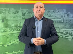 Hombre de pie frente a un fondo de la ciudad de Melilla