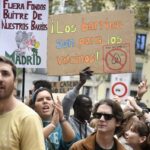 Jóvenes en una manifestación sosteniendo carteles sobre los barrios.