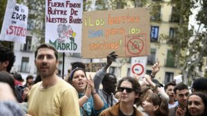 Jóvenes en una manifestación sosteniendo carteles sobre los barrios.