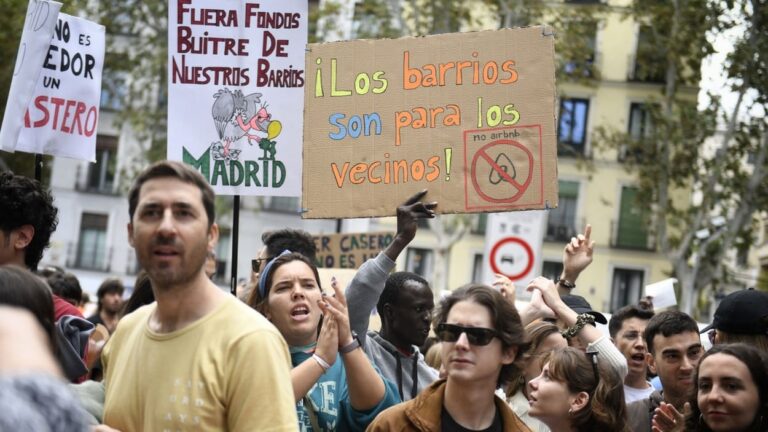 Jóvenes en una manifestación sosteniendo carteles sobre los barrios.