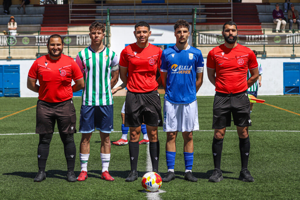 Cinco jugadores de fútbol posando en el campo antes del partido.