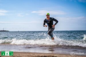 Triatleta Manolo Martínez corriendo en la playa durante el triatlón