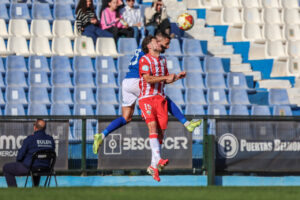 Jugadores de fútbol en acción durante un partido entre Melilla y Estepona