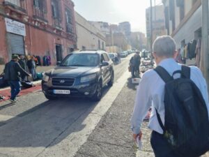 Persona caminando por una calle con un mercado al aire libre en Melilla.