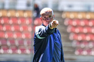 Entrenador Miguel Rivera señalando durante un partido de fútbol.