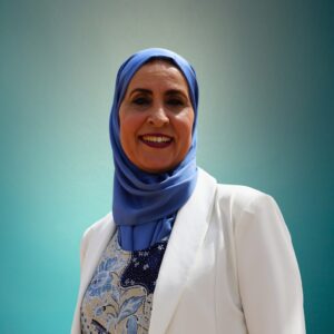 Mujer con hijab azul sonriendo frente a un fondo claro