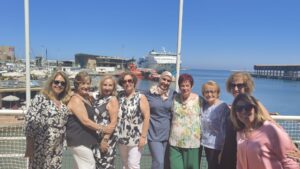 Grupo de mujeres posando en el puerto de Melilla con un barco de fondo