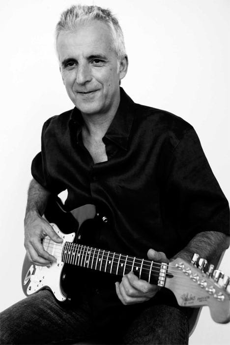 Hombre tocando la guitarra eléctrica en una sesión fotográfica en blanco y negro