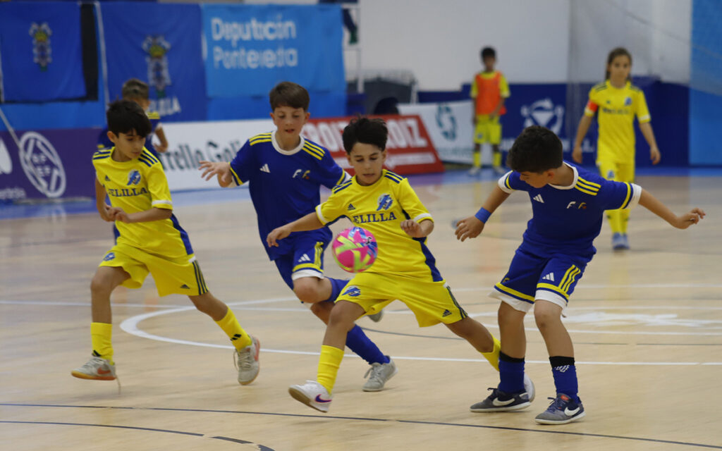Niños jugando al fútbol sala en un partido en Melilla