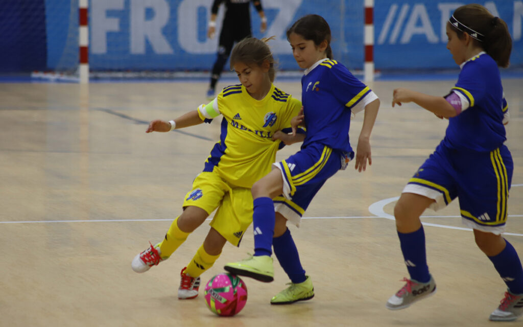 Niñas jugando al fútbol en un partido de sala