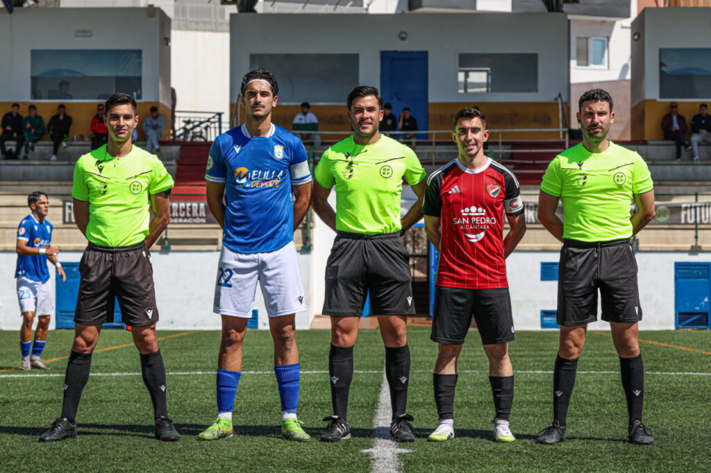 Jugadores y árbitros en el partido entre U.D. Melilla y U.D. San Pedro