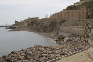 Vista de la playa de La Alcazaba con rocas y murallas