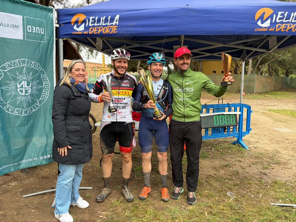 Ciclistas en el podio del Trofeo UNED Melilla con trofeos
